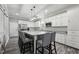 Bright kitchen featuring a large island with seating, white cabinets, and stainless steel appliances at 327F Bobbitt Rd, Clayton, NC 27520