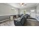 Well-lit living room with hardwood floors, grey walls, a ceiling fan, and cozy couches at 327F Bobbitt Rd, Clayton, NC 27520