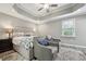 Comfortable main bedroom with tray ceiling, ceiling fan, and sitting area at 327F Bobbitt Rd, Clayton, NC 27520