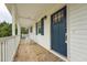 Inviting front porch with rocking chairs, brick flooring, and a blue front door at 327F Bobbitt Rd, Clayton, NC 27520