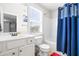 Bright bathroom features a vanity, toilet, and shower with a blue curtain at 36 Labradoodle Ct, Garner, NC 27529