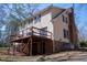 Rear view of the two-story home featuring a backyard deck and brick foundation at 401 Joyce Rd, Hillsborough, NC 27278