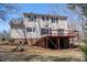 The rear exterior of this two-story home features a deck, backyard, and brick foundation at 401 Joyce Rd, Hillsborough, NC 27278