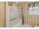 Cozy bathroom featuring a shower-tub combo, patterned wallpaper, and ample natural light from the window at 401 Joyce Rd, Hillsborough, NC 27278