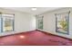Empty bedroom with three windows and red carpet ready for furniture at 401 Joyce Rd, Hillsborough, NC 27278