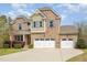 Beautiful two-story brick home featuring a three-car garage, manicured landscaping, and porch at 401 Molina Ct, Rolesville, NC 27571