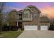 Charming two-story brick home featuring a three-car garage and manicured landscaping at 401 Molina Ct, Rolesville, NC 27571