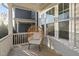 Cozy covered porch with a wicker chair, white columns, and ample natural light at 416 Holding Creek Dr, Wake Forest, NC 27587