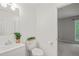 Bright bathroom with a white vanity, toilet topped with a decorative plant, and a window to the outdoors at 4601 Timbermill Ct # 302, Raleigh, NC 27612