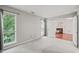 Bright bedroom with large windows and doorway to living room with fireplace at 4601 Timbermill Ct # 302, Raleigh, NC 27612