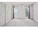 Light-filled bedroom featuring neutral carpet, two windows with curtains, and double closets for ample storage at 4601 Timbermill Ct # 302, Raleigh, NC 27612