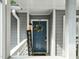 Charming front door with a wreath, welcome sign, and overhead lighting at 4601 Timbermill Ct # 302, Raleigh, NC 27612