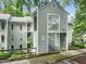 Gray two-story condominium building with landscaped yard, sidewalk, and wooden fence at 4601 Timbermill Ct # 302, Raleigh, NC 27612