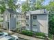Three-story condo building featuring balconies, a gray exterior, and manicured landscaping, offering a blend of comfort and style at 4601 Timbermill Ct # 302, Raleigh, NC 27612