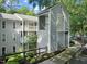 Attractive condo building featuring gray siding, white trim, a charming entryway, and well-maintained landscaping at 4601 Timbermill Ct # 302, Raleigh, NC 27612