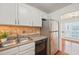 Kitchen with white cabinets, stainless steel refrigerator and hardwood floors at 4601 Timbermill Ct # 302, Raleigh, NC 27612