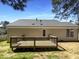 A wooden deck sits in the backyard of a home with a grey roof at 5605 Christie Ln, Durham, NC 27713
