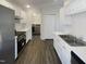 Modern kitchen boasts white cabinets, stainless appliances, and updated countertops at 5605 Christie Ln, Durham, NC 27713