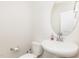 Clean bathroom with a pedestal sink, toilet, and neutral decor, offering a minimalist aesthetic at 609 Embrun Run, Wendell, NC 27591