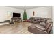 Comfortable living room with a large brown leather sofa, seasonal decor, and wood-look floors at 609 Embrun Run, Wendell, NC 27591