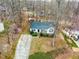 Aerial shot of a charming house featuring a well-kept lawn, a long driveway, and natural surroundings at 6208 Silver Spring Ct, Willow Springs, NC 27592