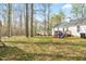 Spacious backyard with mature trees, a deck and playset at 6208 Silver Spring Ct, Willow Springs, NC 27592