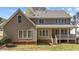 Expansive back of house featuring a charming, covered porch with white railings and multiple windows for natural light at 749 Hadrian Dr, Garner, NC 27529