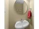 Powder room with a pedestal sink, round mirror, and neutral wall color at 749 Hadrian Dr, Garner, NC 27529