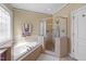 This bathroom features a soaking tub, glass enclosed shower, and neutral finishes at 749 Hadrian Dr, Garner, NC 27529