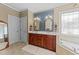 Bathroom showcasing the double vanity, mirrors, and soaking tub at 749 Hadrian Dr, Garner, NC 27529