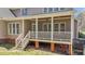 Inviting covered back porch with ceiling fan, white railings, and steps leading down to the yard at 749 Hadrian Dr, Garner, NC 27529