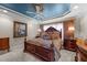 Luxurious main bedroom with tray ceiling, ceiling fan, and dark wood furniture at 749 Hadrian Dr, Garner, NC 27529