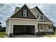 A beige two-story home exhibits a two-car attached garage and black shutters accenting the windows at 85 Prency Ln, Middlesex, NC 27557
