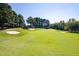 Scenic view of a golf course with lush green fairways, sand traps, and mature trees at 904 Hidden Jewel Ln, Wake Forest, NC 27587