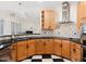 Updated kitchen featuring wooden cabinets, black countertops, and a view to the living room at 904 Hidden Jewel Ln, Wake Forest, NC 27587