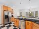 Traditional eat-in kitchen featuring black countertops, stainless appliances, and checkerboard flooring at 904 Hidden Jewel Ln, Wake Forest, NC 27587