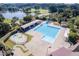 Aerial view of a community pool featuring a slide, diving board, and baby pool with lake and golf course in the background at 904 Hidden Jewel Ln, Wake Forest, NC 27587