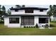 Back exterior view of a modern home with patio, screened porch, and well-maintained lawn at 95 Cherry Bark Dr, Youngsville, NC 27596