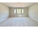 Spacious bedroom with neutral paint and three large windows at 95 Cherry Bark Dr, Youngsville, NC 27596