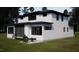 Charming two-story home with white siding, black trim and a cozy outdoor seating area at 95 Cherry Bark Dr, Youngsville, NC 27596