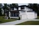 Striking two-story home with modern architecture, a manicured lawn and a three car garage at 95 Cherry Bark Dr, Youngsville, NC 27596
