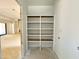 Unfinished walk-in pantry showcasing empty white shelving and natural light at 95 Cherry Bark Dr, Youngsville, NC 27596