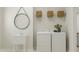 Modern laundry room featuring white washer, dryer, sink, and shelving at 300 Calvander Ln, Apex, NC 27539