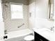 Bright bathroom featuring tiled shower and bath, white subway tiles, and a modern vanity with marble countertop at 1 Greenfield Ct, Durham, NC 27705