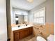 Bathroom with double vanity, beige tile accents, and a bright window at 1 Greenfield Ct, Durham, NC 27705