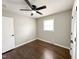 Cozy bedroom featuring hardwood floors, neutral paint, a ceiling fan, and a bright window for natural light at 1 Greenfield Ct, Durham, NC 27705