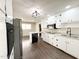 Updated kitchen with white cabinets, modern lighting, stainless appliances, and an island at 1 Greenfield Ct, Durham, NC 27705
