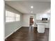 Bright living room featuring hardwood floors, white walls, and plenty of natural light from the large windows at 1 Greenfield Ct, Durham, NC 27705