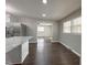 Open-concept living room with a view of the kitchen's island and stainless steel appliances, all with modern finishes at 1 Greenfield Ct, Durham, NC 27705