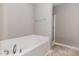 A clean bathroom showcases a white soaking tub and a glass-enclosed shower at 102 Bella Pl, Holly Springs, NC 27540